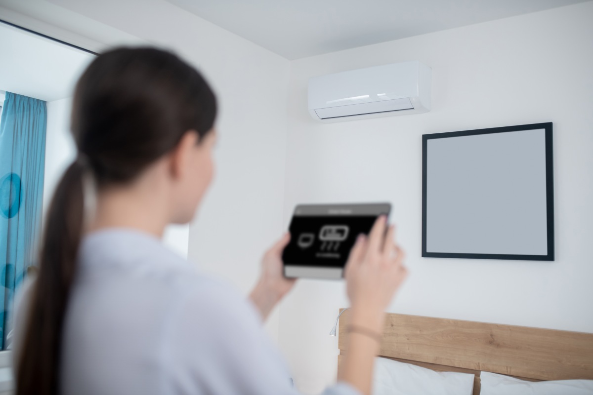Žena zapína klimatizáciu od smartsystems tabletom.